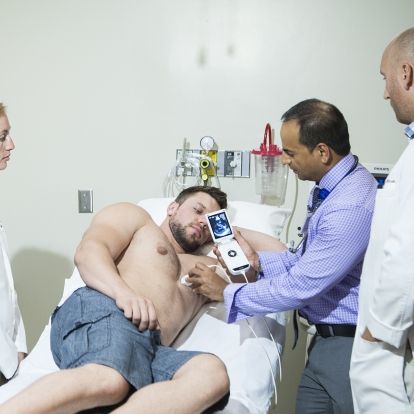 Dr Amer Johri of the KGH Research Institute emonstrates the use of a portable hand-held ultrasound at a patient's bedside.
