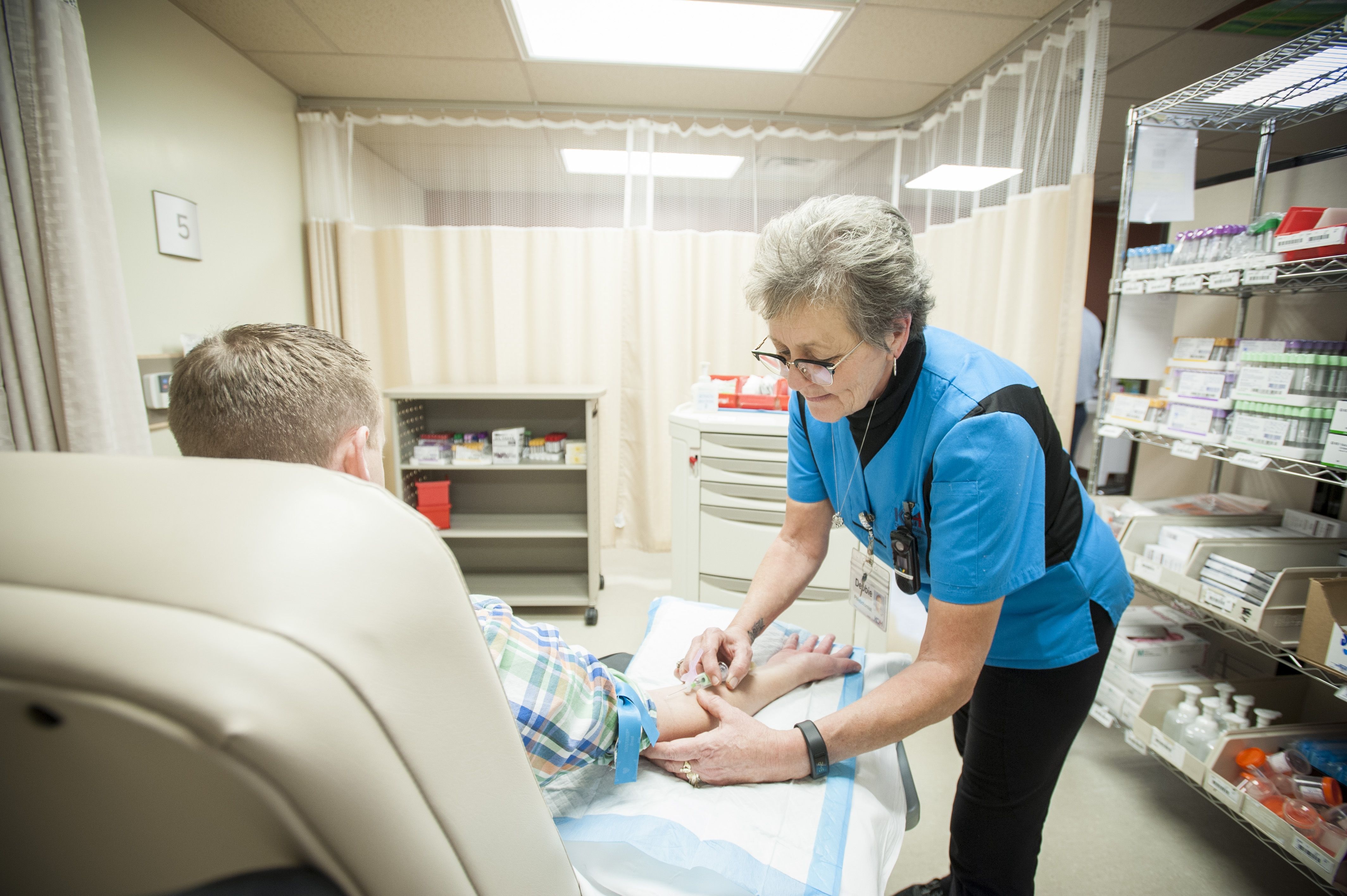 Phlebotomist Deb Webster at work in one of the stations in the relocated Blood Room in the Burr wing lobby.