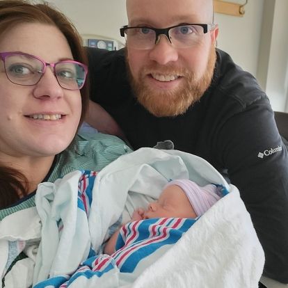 young couple holding newborn baby