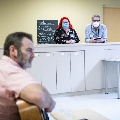 Music therapy 2 Staff watch a guitarist performing for patients.