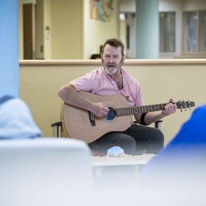 A guitarist plays for patients.