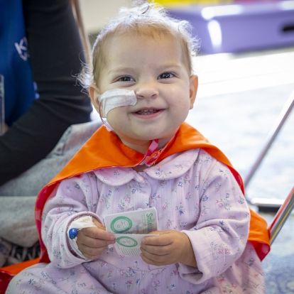 a young patient wearing a cape at KHSC