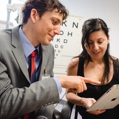 Dr. Mark Bona (left) and a patient in the Vision Rehabilitation Clinic at the HDH site: the use of visual aids/technologies such as tablets to improve the person's ability to function independently.