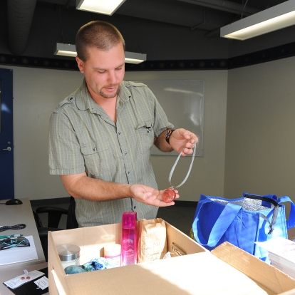 Chris Hammer, KGH Employee Campaign Coordinator, organizing donated items for the Early Bird gift basket draw.
