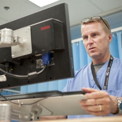 Physician Dr. Paul Dungey use a computer at the nursing station in our Emergency department to do his electronic charting.
