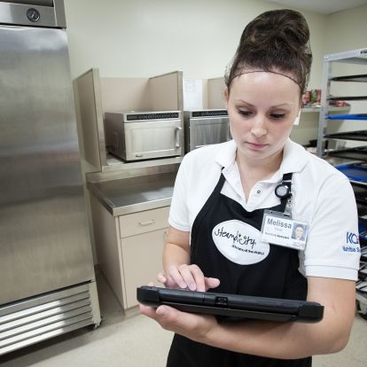 Nutrition Assistant Melissa Sauve prepares meals for patient's on Davies 5 using a new hand-held tablet that helps her build the patient's meal order.