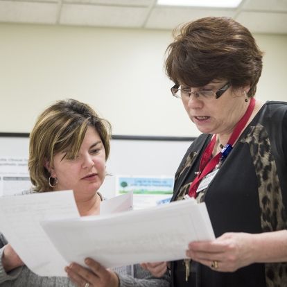 (From left) Rachael Smith-Tryon, Manager of Admitting, Registration and Switchboard and Kellie Kitchen, Program Operational Director for OBS/GYN/PEDS/SPA, have a quick meeting as part of the daily huddles