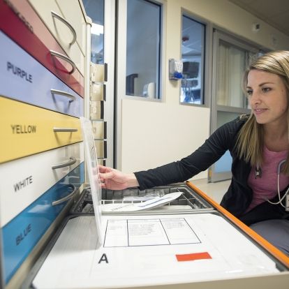 Registered Nurse Janice McLure checks out the new pediatric rainbow cart that recently arrived on Kidd 10.