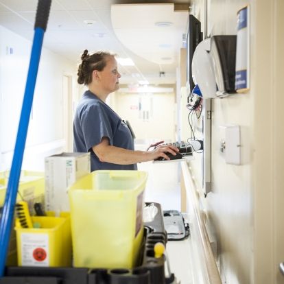 Debora Petrie, Environmental Services Assistant, goes online to let people know another bed is clean.