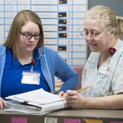 Cheryl Cannon, RN, and Katherine Stringer, Patient Care Navigator, wear the heart-shaped ID badge clips they received after completing the Communicate with HEART training program.