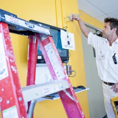 Painter Raymond Houle puts the final touches on a wall near the 'Tuck Shop' bearing the colour of the Connell wing.
