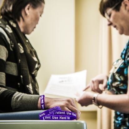 Registered Nurse Andrea Knapp (right) draws blood from the hand of renal patient Cecilia Tran.