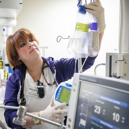 Registered Nurse Allyssa Zeagman setting up IV bags with nutrition in them for an ICU patient.