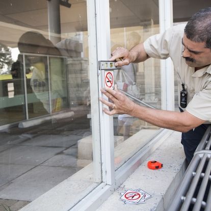 Dave De Sousa measuring up areas outside of the Burr wing where some new non-smoking signs are going to be installed.