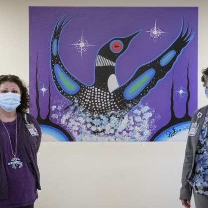 staff posing with art work