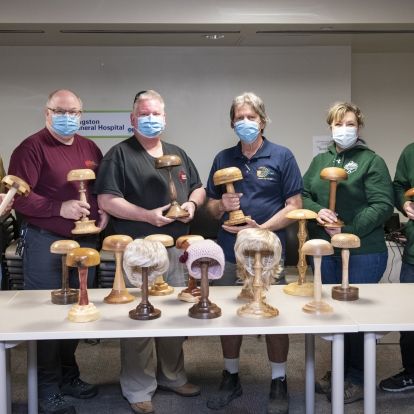 Members of the Kingston Woodturners with the donated wig stands