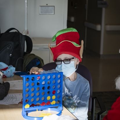 Santa stops for a game of Connect 4 with one of our pediatric patients