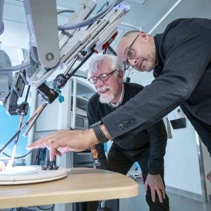 Dr. Robert Siemens and Mr. David Bailey, a patient who received robotics assisted surgery, review the functionality of the newly launched robotic surgical system
