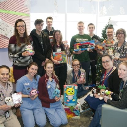 Members of the Holy Cross senior boys basketball team donate toys to pediatric patients this Christmas