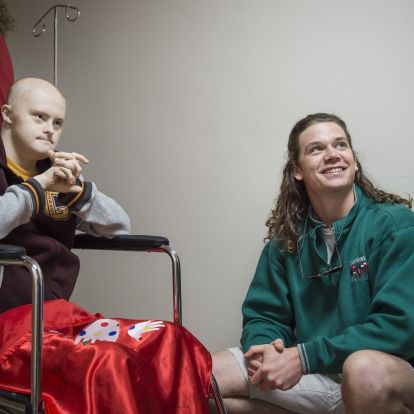 Josh and Andrew wait in the hallway outside the hair salon