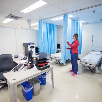 Jessa Rego, RN, prepares two of the six stations for patients.