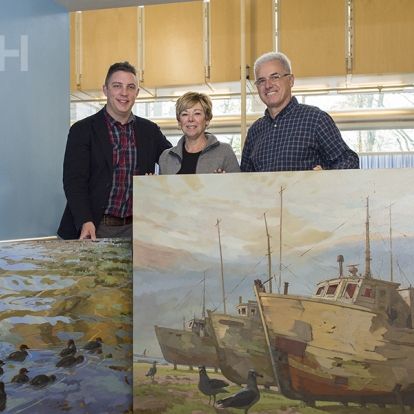 (Left) Tyler Hands, Program Manager of Inpatient and Ambulatory Oncology, thanks artist Robert Shackles and his wife Sylvia for their two big donations to our art collection.