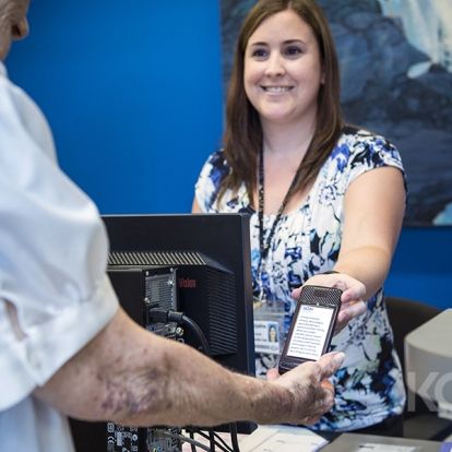 Jacqueline Howarth, Registration Clerk, hands out a pager to a patient in the Cancer Centre.