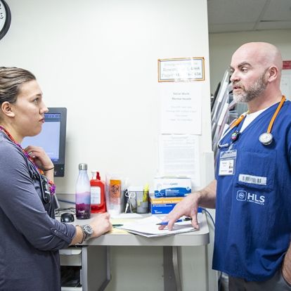 In his pilot role as Mental Health Nurse Navigator in the ED, Richard Cook, right, works closely with Social Worker Sarina Cormier, left, and other members of the ED team to speed up treatment and reduce wait times for patients with mental health emergencies.