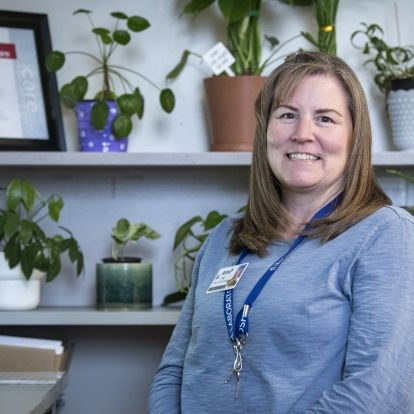 Anne Vincent is pictured inside her office at KHSC's Kingston General Hospital site. She has shoulder length, brown hair and is wearing a blue, long-sleeved shirt.
