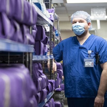 Bradley Leaver is wearing blue scrubs and photographed inside the Medical Device Reprocessing department at KHSC.