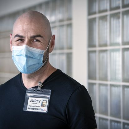 Jeffrey Lalonde is pictured in a hallway at the KGH site. He has dark brown eyes and is bald. He’s wearing a navy blue, V-neck top.