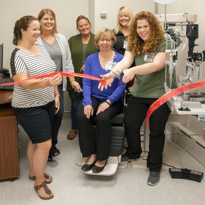 red ribbon cutting for renovated clinic