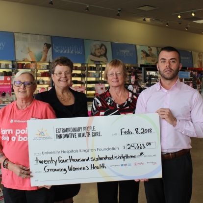Staff from Shoppers Drug Mart present a cheque to representatives from the UHKF