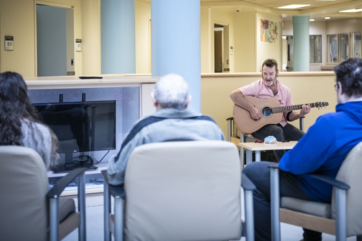 A guitarist plays for patients.