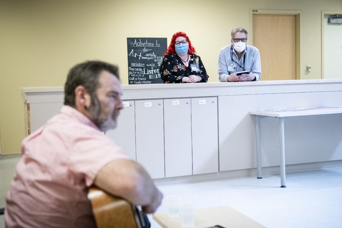 Music therapy 2 Staff watch a guitarist performing for patients.