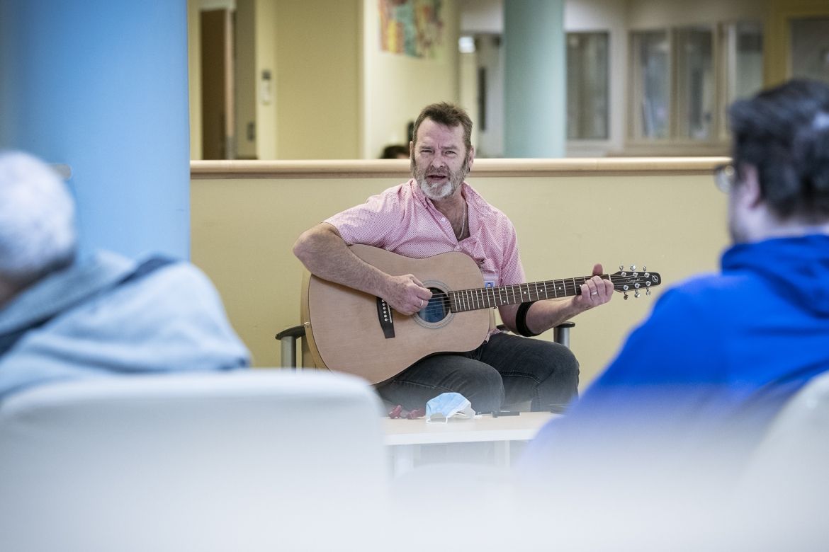 A guitarist plays for patients.