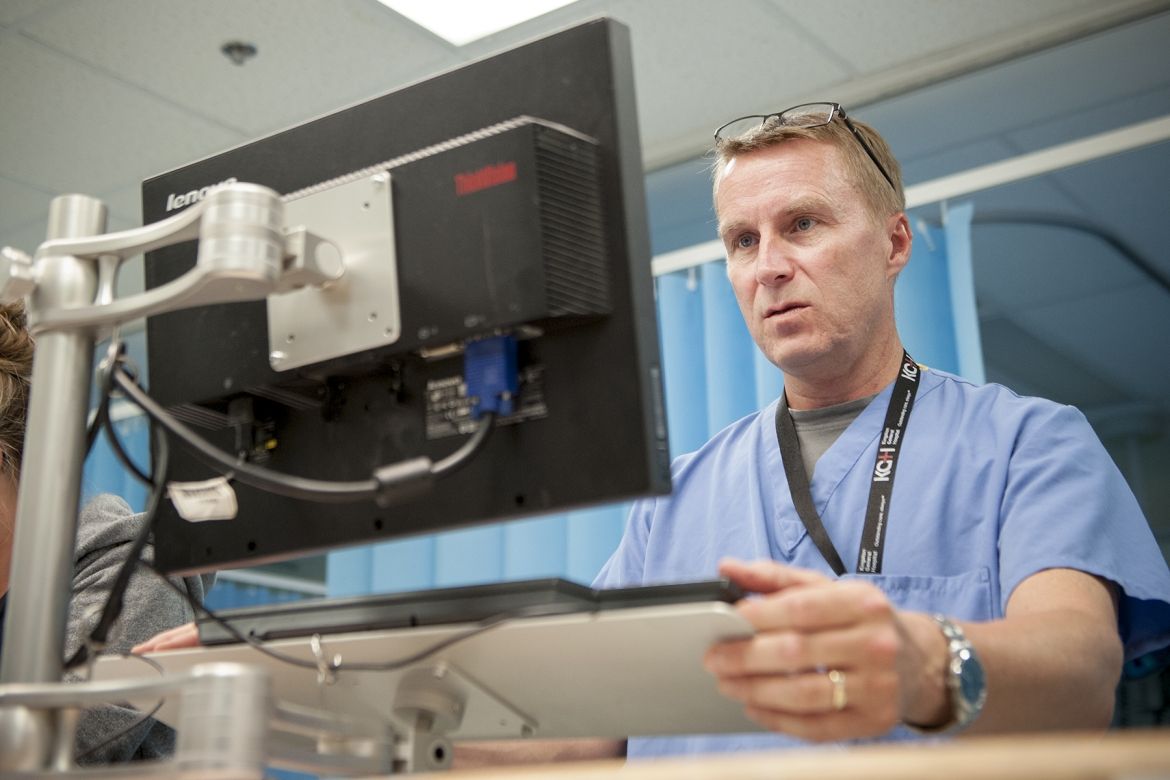 Physician Dr. Paul Dungey use a computer at the nursing station in our Emergency department to do his electronic charting.