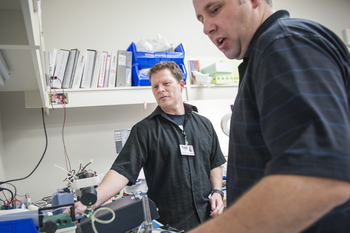 Biomedical Technologists Todd Gowlett (left) and William Raney work on equipment in KGH's Ventilator Pool. The team cut wait times from an average of 10 weeks to two.