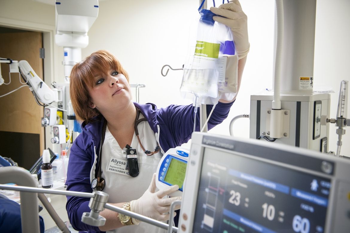 Registered Nurse Allyssa Zeagman setting up IV bags with nutrition in them for an ICU patient.
