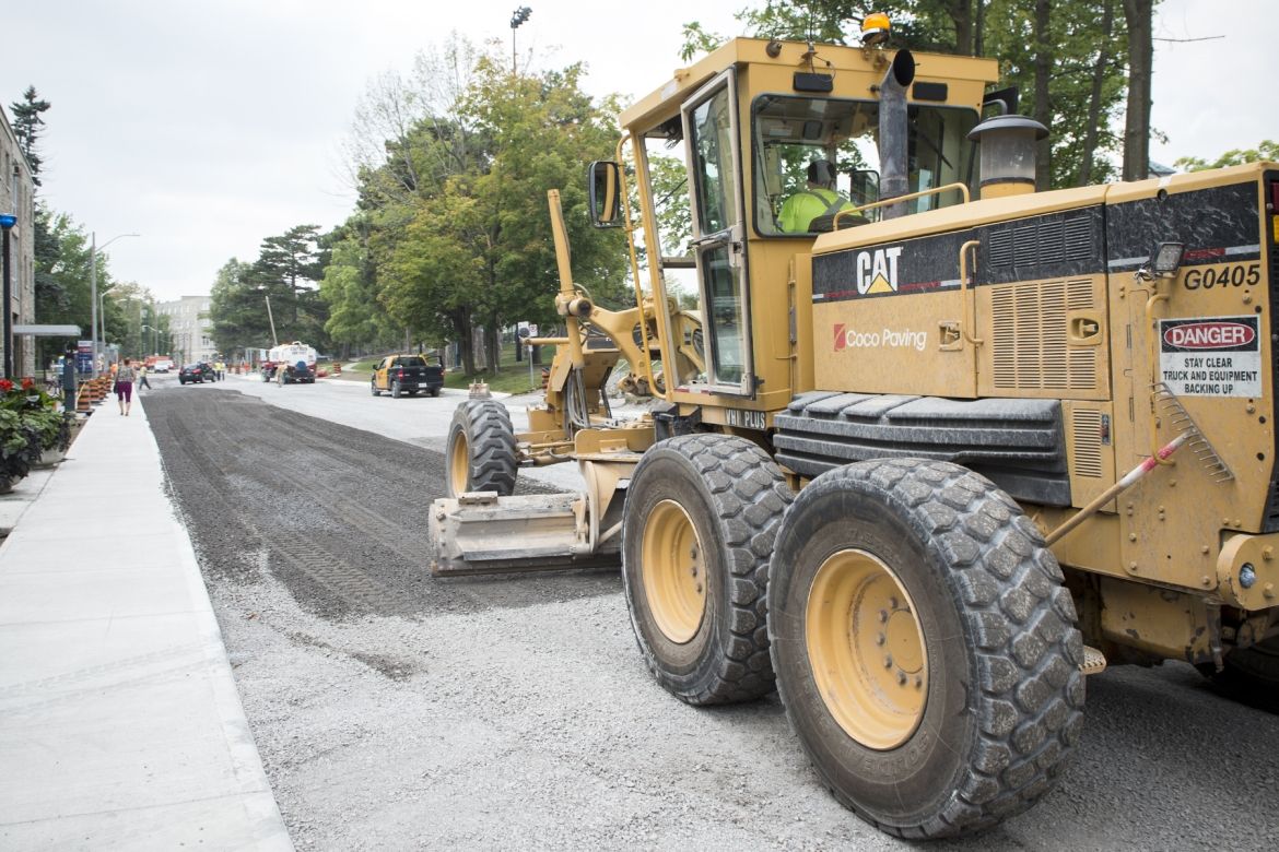 A road grader smooths out the gravel on Stuart Street from the Watkins wing to the main entrance.