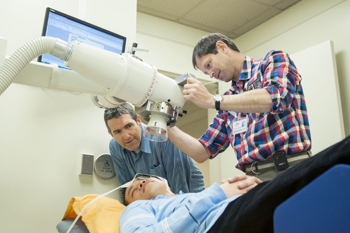 Radiation Therapists David Markotich (left) and Jim Gooding demonstrate how to prepare a patient for radiation treatment using KGH’s new orthovoltage machine.