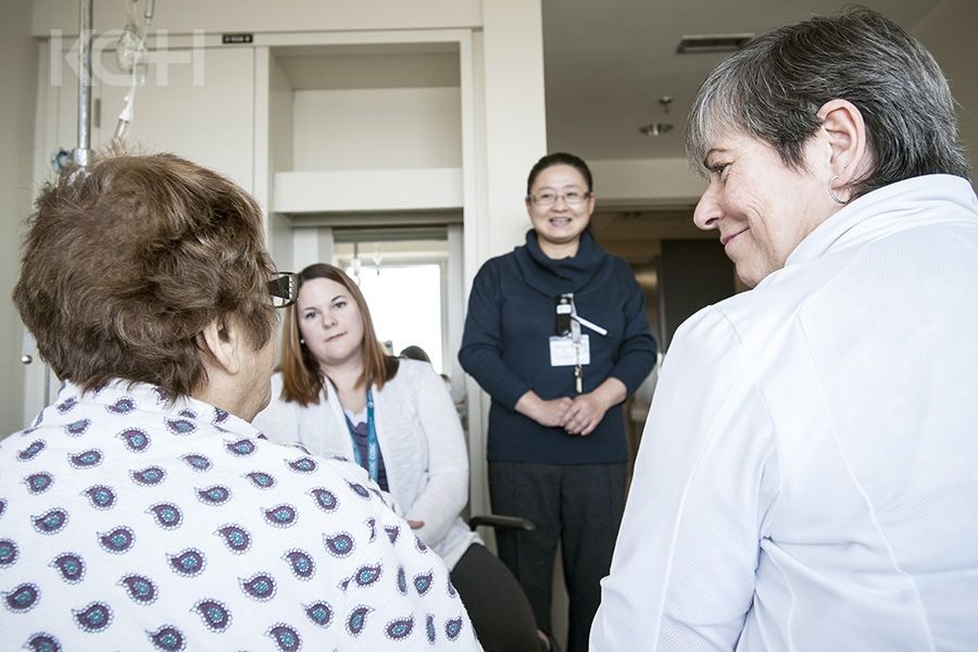 Members of the care team sit and talk with a patient about their plans for discharge.