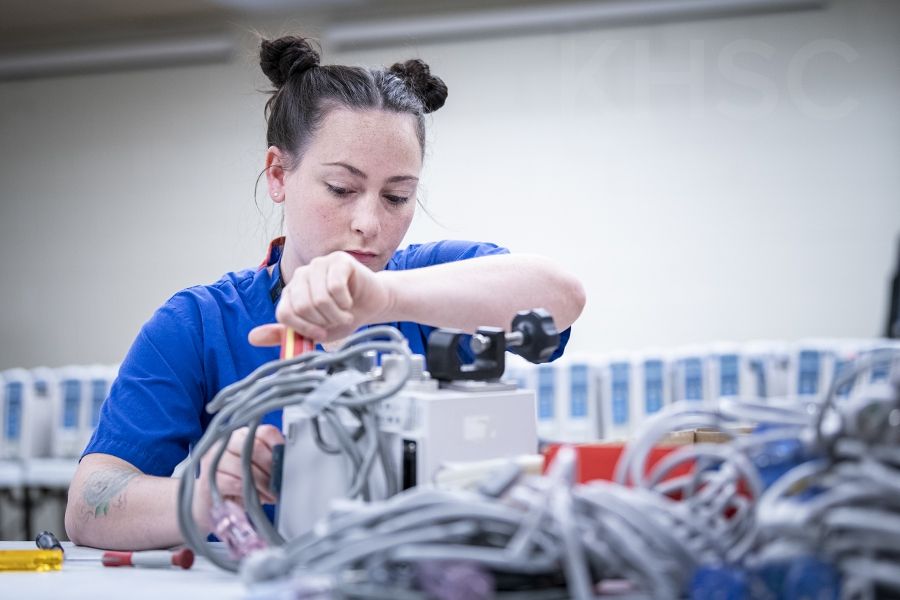 Madeline Rozsa, a Biomedical Technologist with the Clinical Engineering team works on some of the old units as part of the decommissioning process.