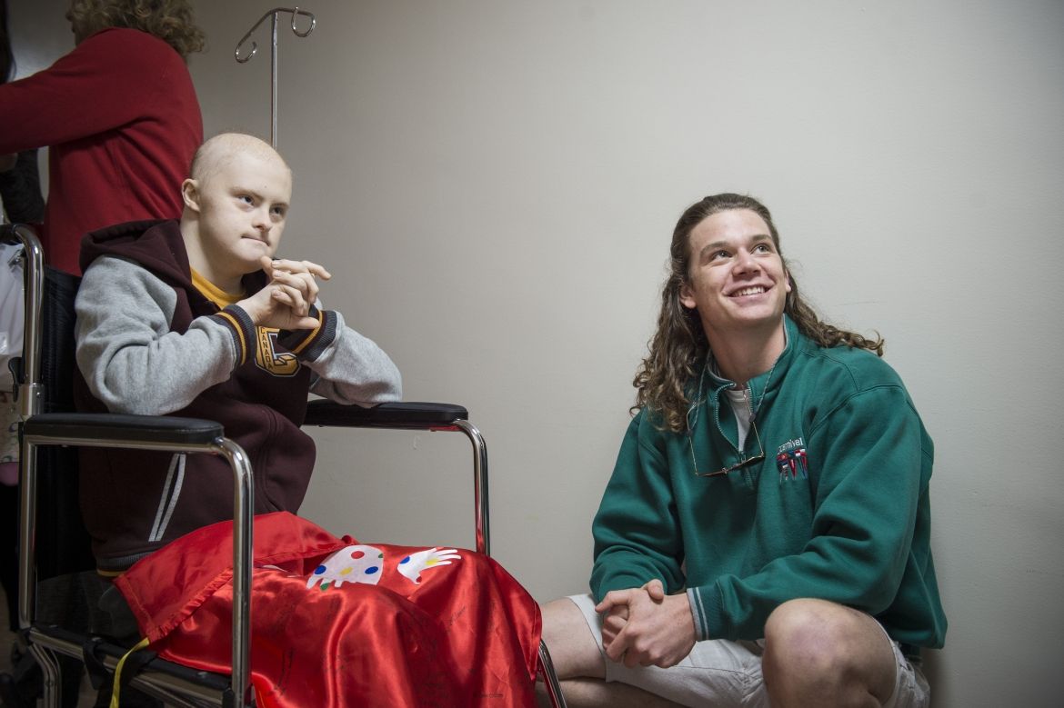 Josh and Andrew wait in the hallway outside the hair salon