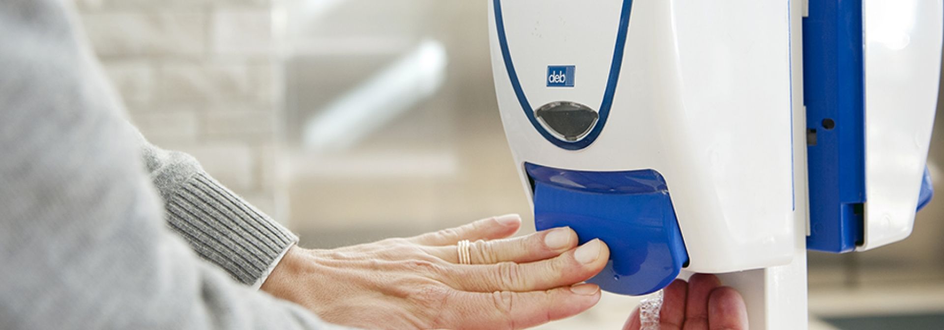 A person using a hand hygiene station at the KGH site.