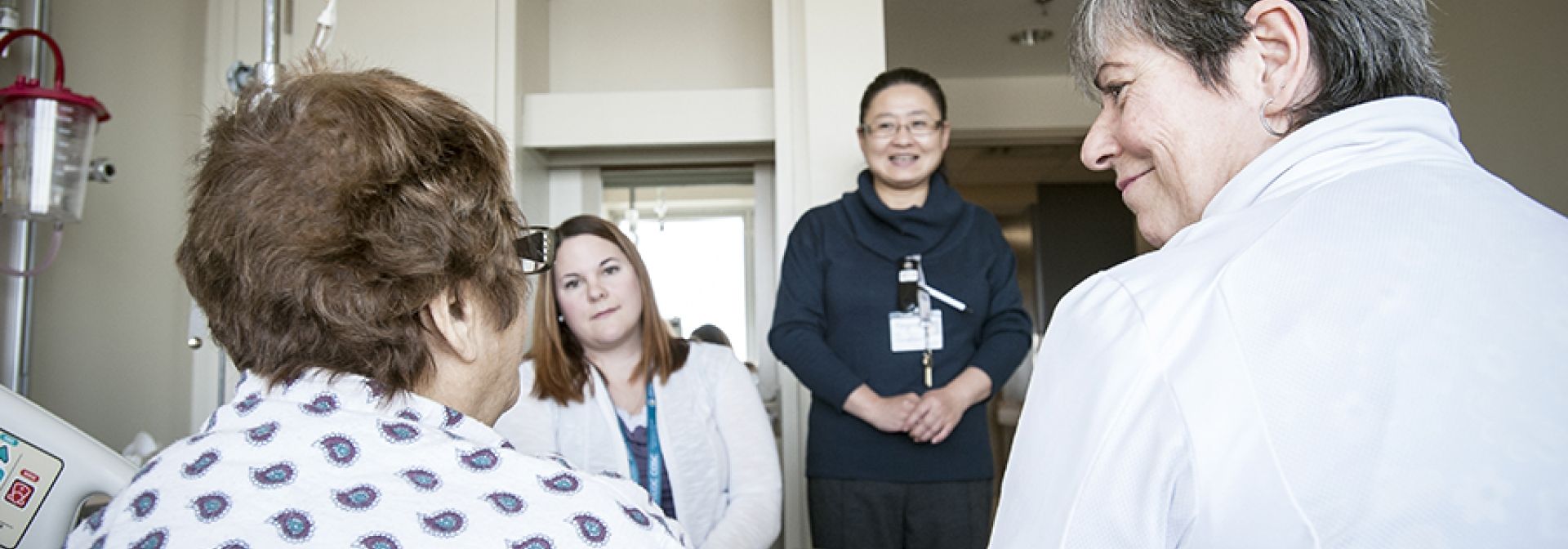 Our care team speaking with a patient in their room.