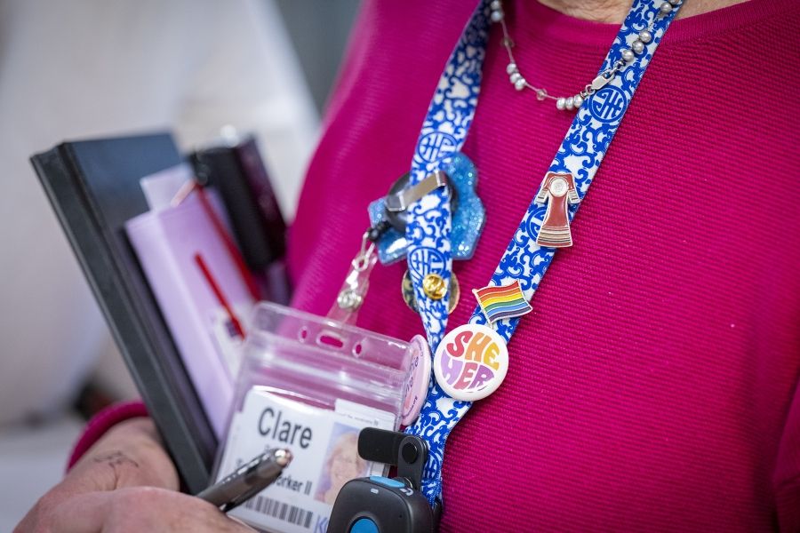 PeopleOfKHSC_Clare_Bowley_4 A close up shot of Clare Bowley’s decorated blue patterned lanyard, which features her KHSC ID badge and a number of pins like the Pride flag.