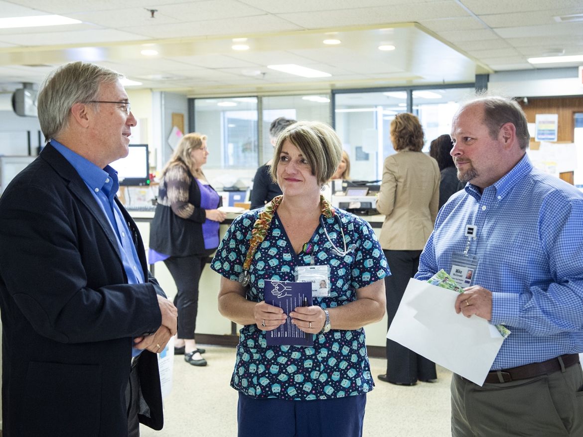 KHSC President and CEO Dr. David Pichora and Mike McDonald, Executive Vice President, Patient Care and Community Partnerships discuss the Transforming care, together strategy with a nurse in the Urgent Care Clinic