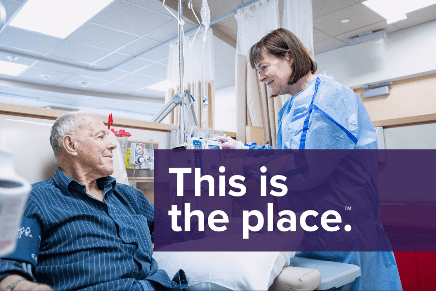 An oncology nurse speaks with a patient undergoing treatment. 