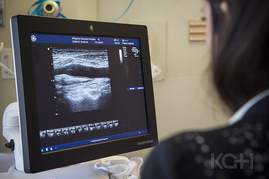 A healthcare practitioner using an ultrasound machine on a patients neck.